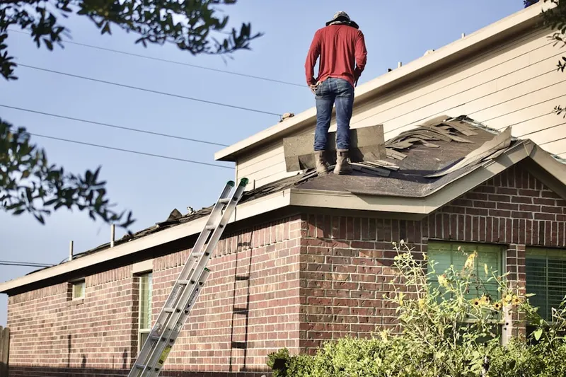Professional roofer working on a residential roof in Elk